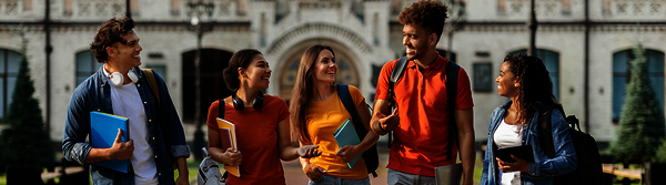 Fünf internationale Studiernde mit Taschen und Schreibunterlagen im Gespräch vor einem historischen Gebäude.